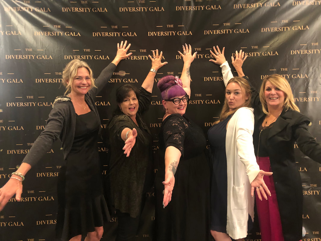 five women in front of diversity gala banner